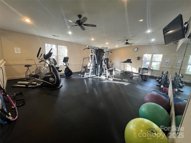 exercise room featuring ceiling fan, a textured ceiling, and a wealth of natural light