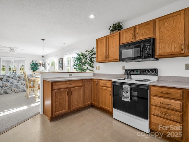 kitchen featuring light carpet, ceiling fan with notable chandelier, hanging light fixtures, white electric range oven, and kitchen peninsula