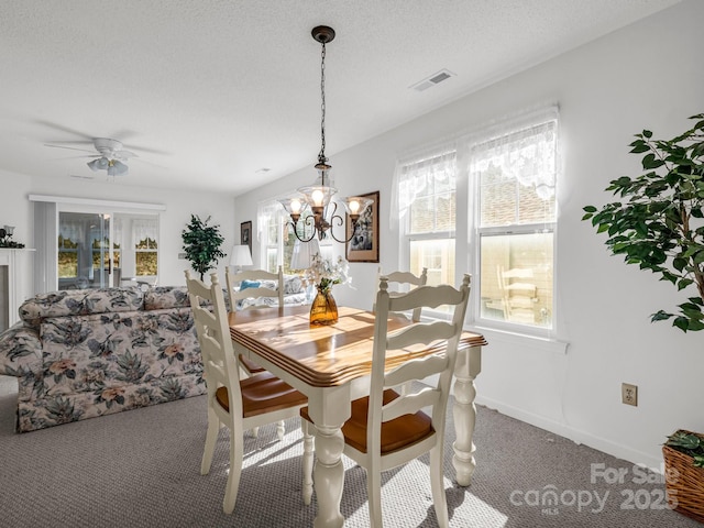 dining room with ceiling fan with notable chandelier, a textured ceiling, and carpet floors