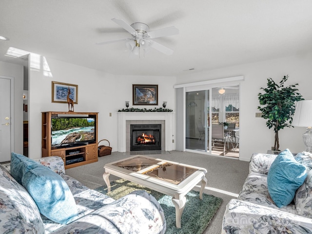 carpeted living room with a tile fireplace and ceiling fan