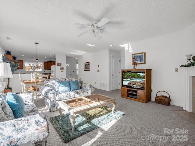 carpeted living room featuring ceiling fan with notable chandelier