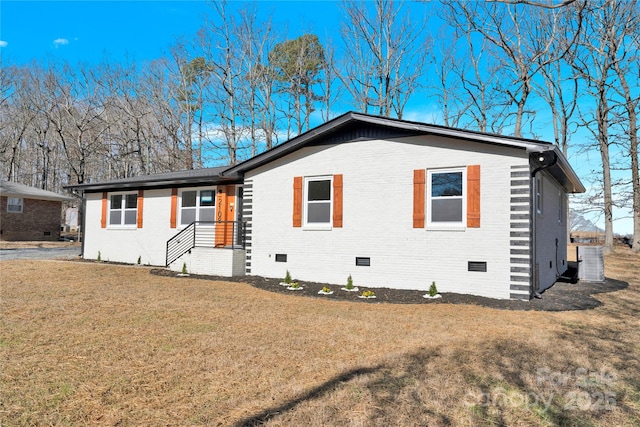 view of front of property with central AC and a front yard