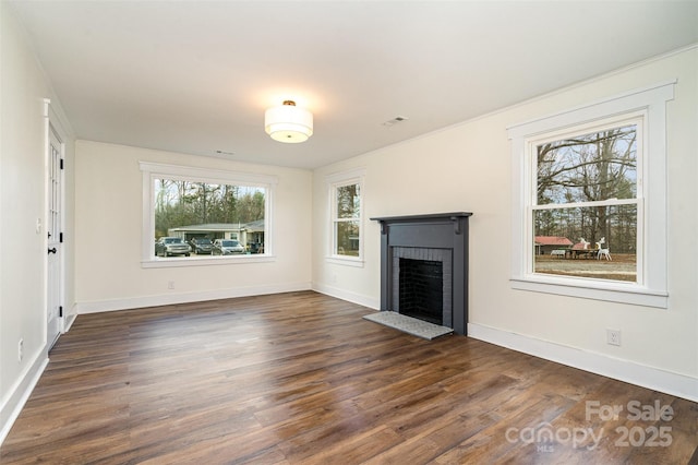 unfurnished living room featuring a brick fireplace and dark wood-type flooring