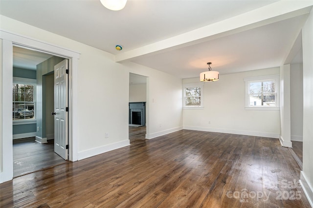 unfurnished living room featuring beamed ceiling and dark wood-type flooring