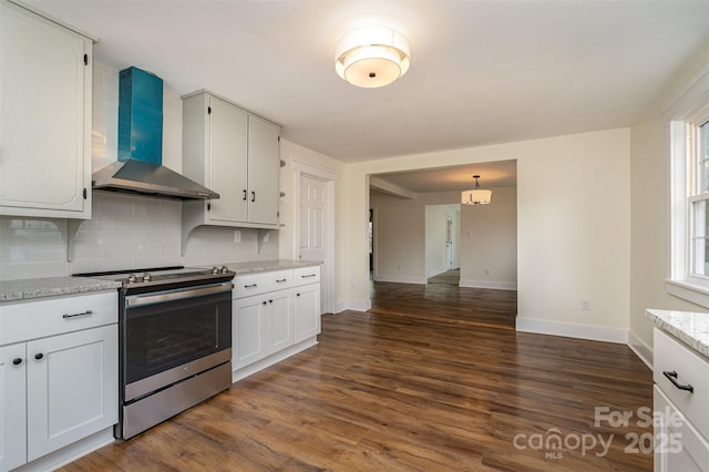 kitchen featuring electric stove, white cabinets, light stone counters, and wall chimney exhaust hood