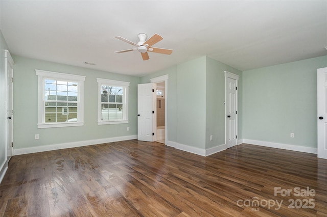 empty room with ceiling fan and dark hardwood / wood-style flooring