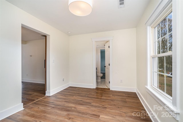 spare room featuring dark hardwood / wood-style floors and a wealth of natural light