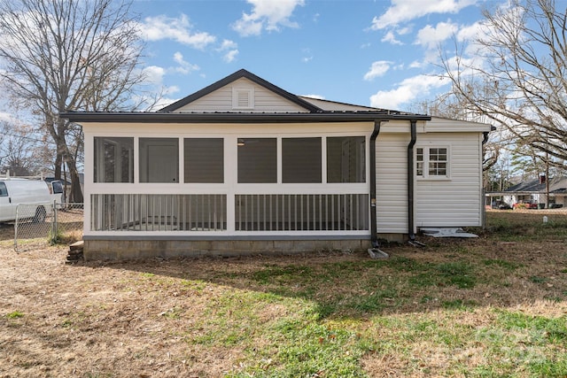 rear view of property with a yard and a sunroom