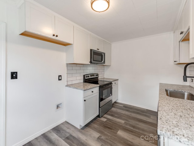 kitchen featuring sink, black range with electric cooktop, light stone counters, decorative backsplash, and white cabinets