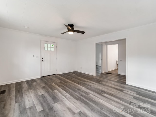 empty room featuring ceiling fan, dark wood-type flooring, and ornamental molding