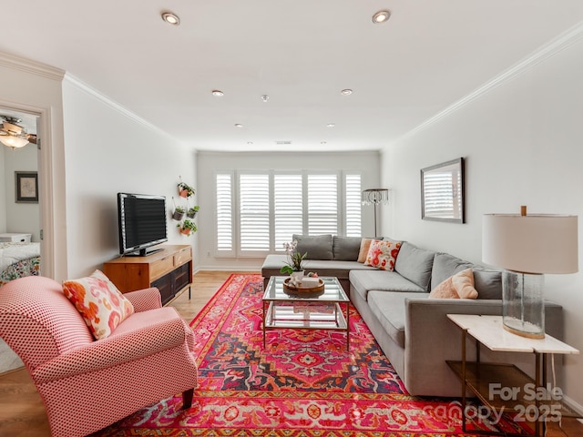 living room featuring light wood-type flooring and crown molding