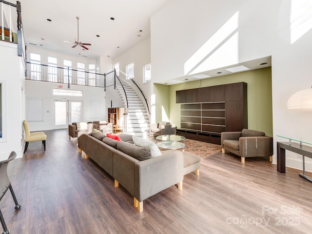 living room featuring a high ceiling, hardwood / wood-style floors, and ceiling fan