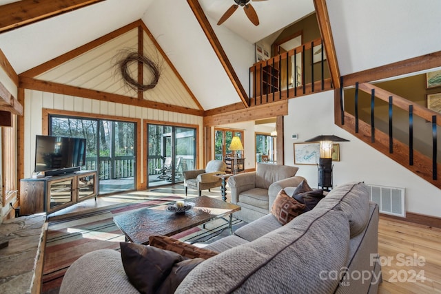 living room featuring ceiling fan, high vaulted ceiling, and light hardwood / wood-style flooring