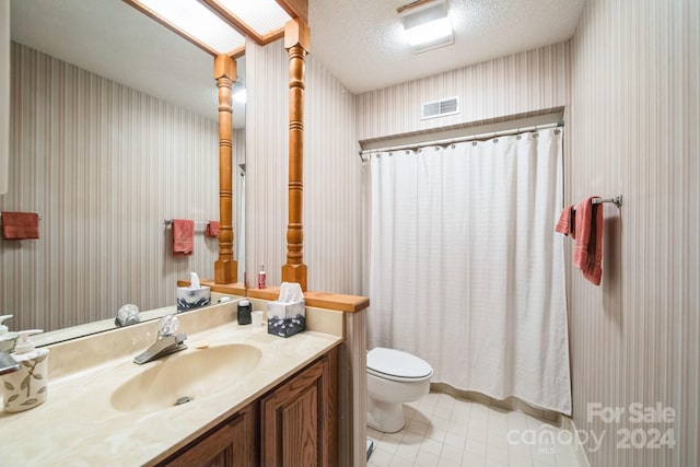 bathroom featuring vanity, tile patterned floors, a shower with curtain, toilet, and a textured ceiling