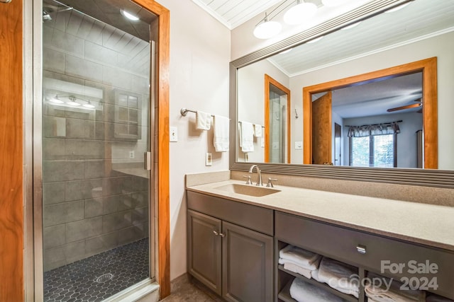 bathroom featuring vanity, ceiling fan, an enclosed shower, and crown molding