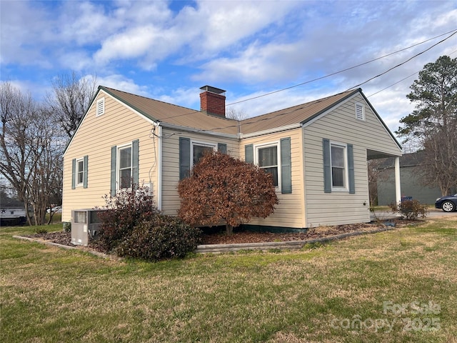 view of side of home with a yard and central AC unit