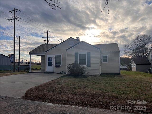 view of front of home with a carport and a front lawn