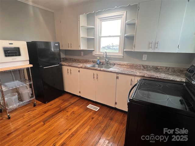 kitchen featuring white cabinets, sink, hardwood / wood-style floors, and black appliances