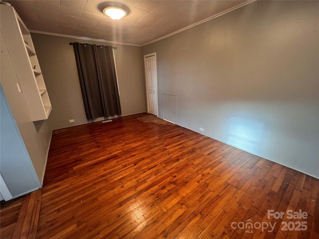 spare room featuring hardwood / wood-style flooring and ornamental molding