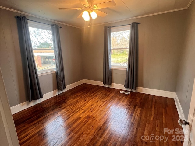 unfurnished room featuring ornamental molding, wood-type flooring, ceiling fan, and a healthy amount of sunlight