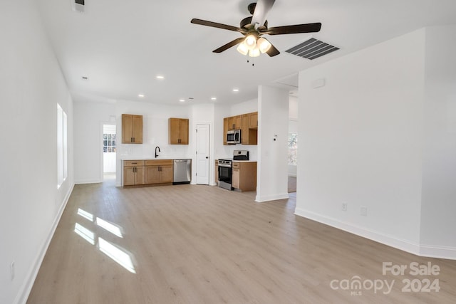 unfurnished living room with light wood-type flooring and ceiling fan