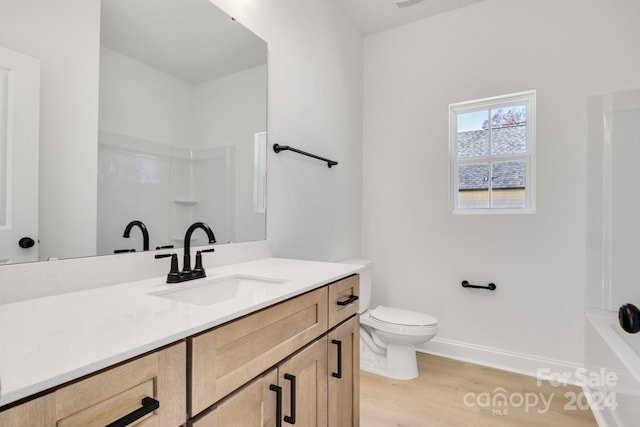 bathroom with hardwood / wood-style floors, vanity, and toilet