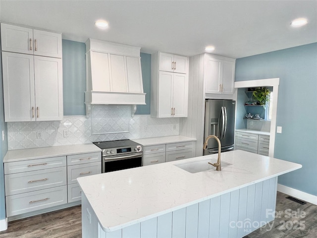 kitchen featuring appliances with stainless steel finishes, an island with sink, custom exhaust hood, and sink