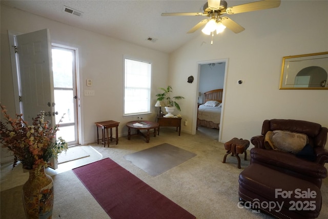 carpeted living room with ceiling fan and lofted ceiling