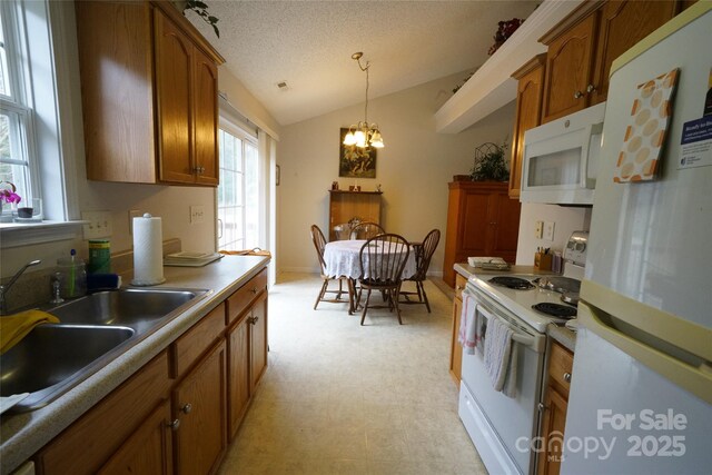 kitchen with white appliances, vaulted ceiling, a chandelier, pendant lighting, and sink