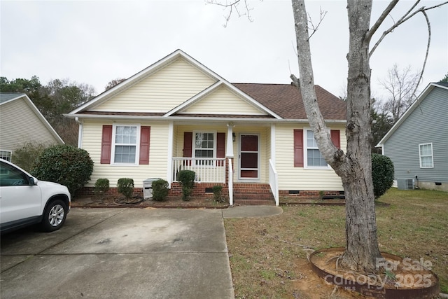 view of front facade with covered porch, a front lawn, and central AC unit