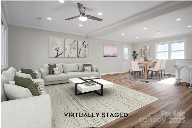 living room featuring hardwood / wood-style flooring, ceiling fan, and ornamental molding