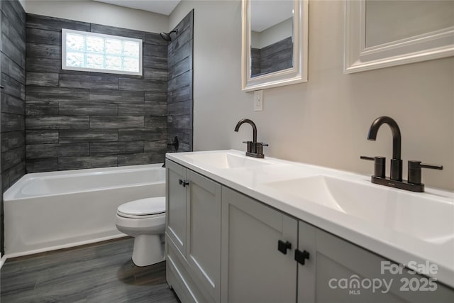 full bathroom with vanity, hardwood / wood-style flooring, toilet, and tiled shower / bath