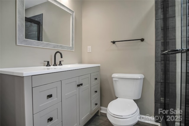 bathroom featuring walk in shower, vanity, and toilet