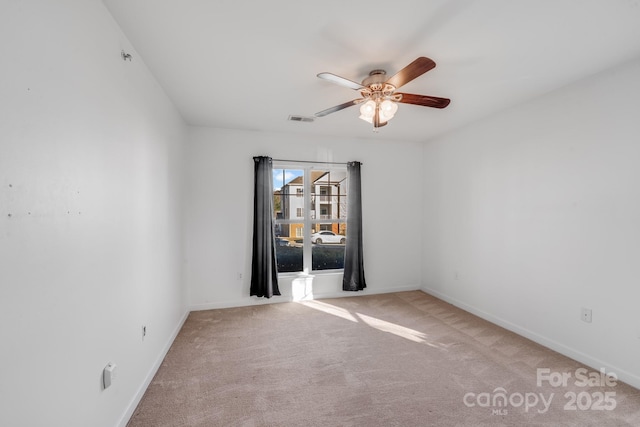 spare room featuring light carpet and ceiling fan