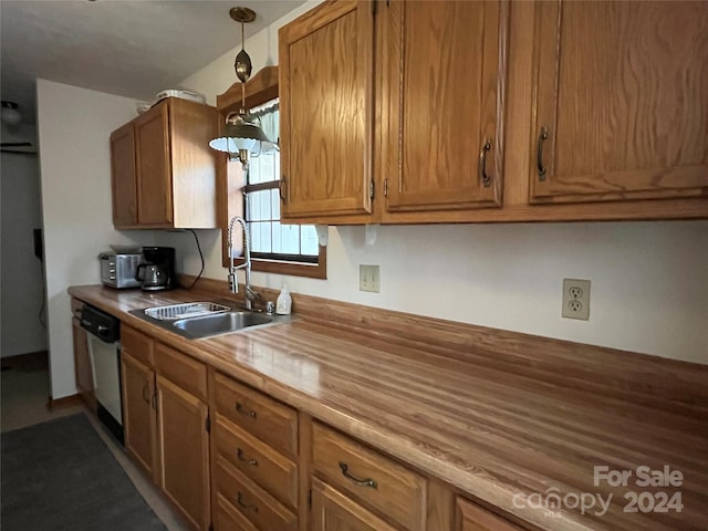 kitchen featuring wood counters, decorative light fixtures, stainless steel dishwasher, and sink