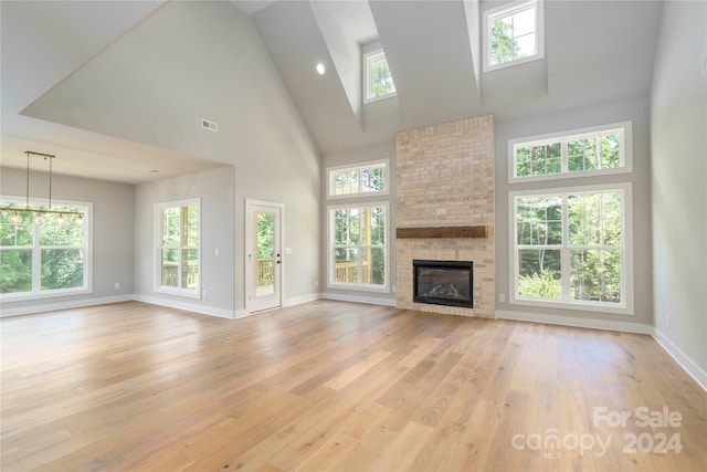 unfurnished living room with a wealth of natural light, a fireplace, and a high ceiling