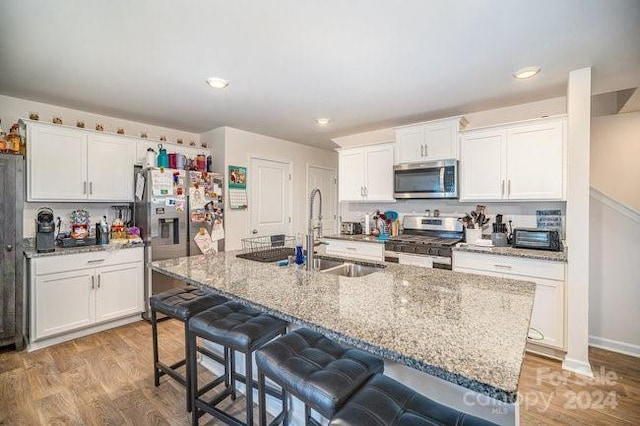 kitchen featuring white cabinets, appliances with stainless steel finishes, and light wood-type flooring