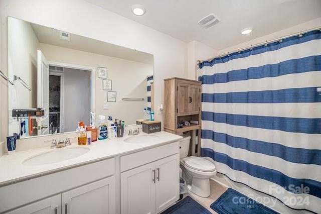 bathroom with tile patterned flooring, vanity, and toilet