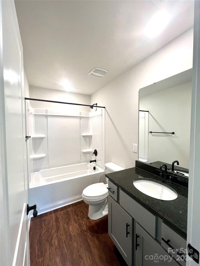 full bathroom featuring hardwood / wood-style flooring, vanity, toilet, and shower / bathing tub combination