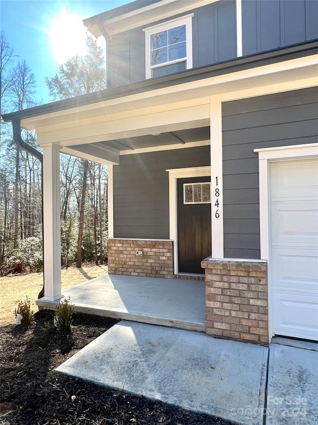 property entrance featuring a garage and covered porch