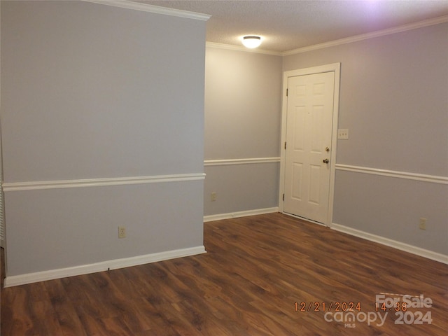 spare room with a textured ceiling, dark hardwood / wood-style floors, and crown molding