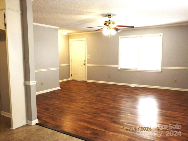 spare room with a textured ceiling, dark hardwood / wood-style floors, ceiling fan, and crown molding