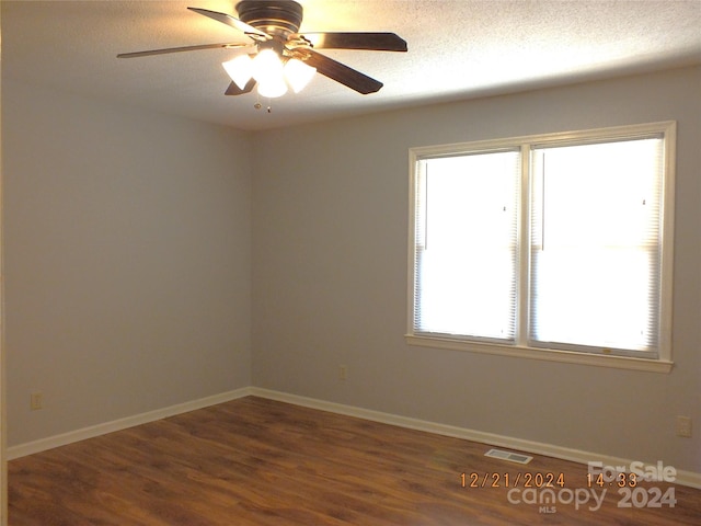 unfurnished room with ceiling fan, dark hardwood / wood-style flooring, and a textured ceiling