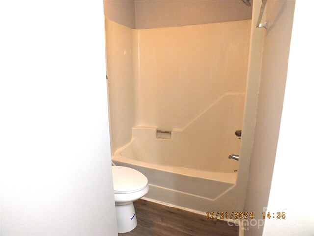 bathroom featuring hardwood / wood-style floors, shower / bathing tub combination, and toilet