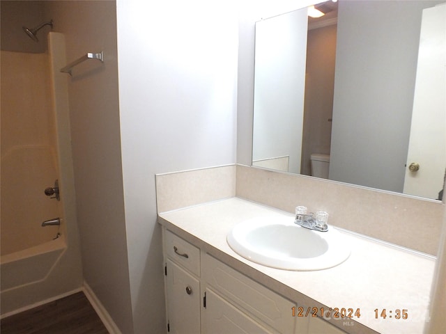 full bathroom featuring shower / tub combination, vanity, wood-type flooring, and toilet