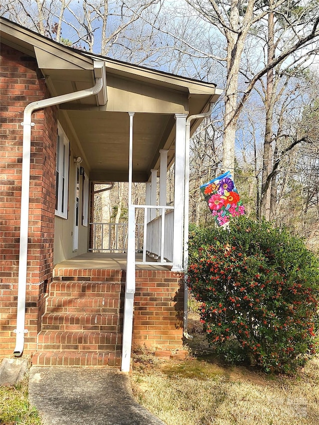 view of property exterior featuring covered porch and brick siding