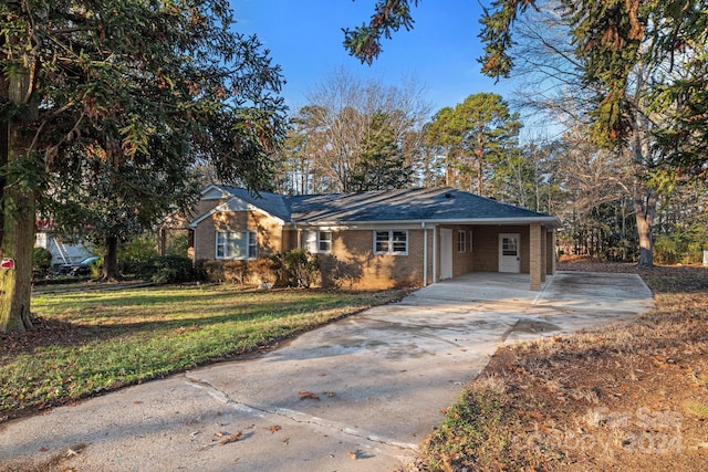 ranch-style home with a carport and a front lawn