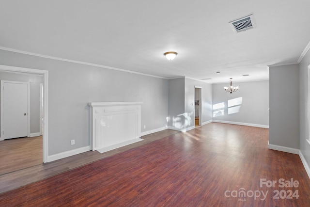 unfurnished living room with a chandelier, dark hardwood / wood-style flooring, and ornamental molding