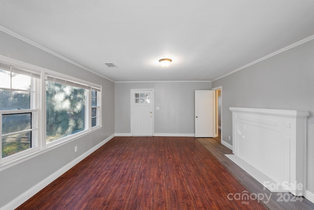 unfurnished room featuring dark wood-type flooring, crown molding, and a healthy amount of sunlight