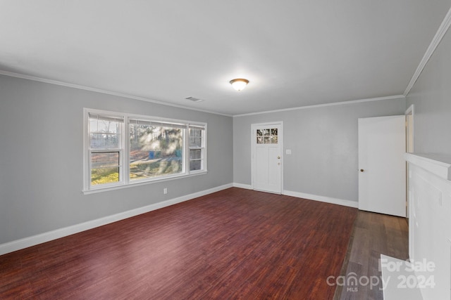 unfurnished room featuring dark wood-type flooring and crown molding